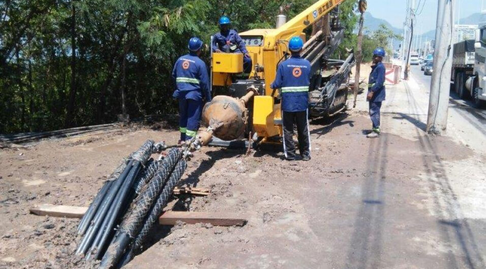 Trabalhadores operando uma máquina efetuando uma perfuração horizontal.